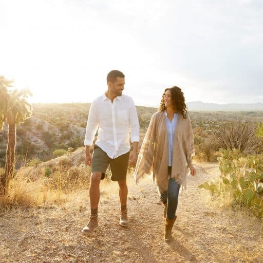 couple looking at each other while walking on a path
