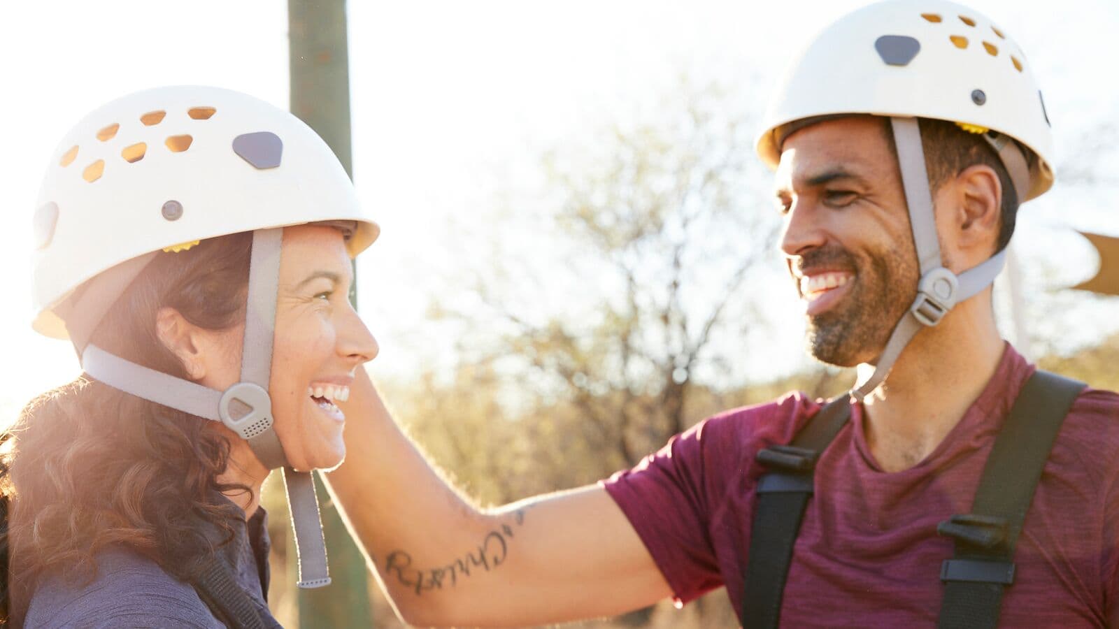 person helping another person put on helmet