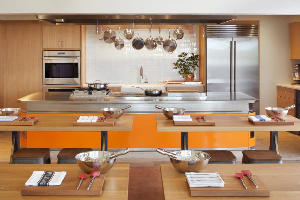 Kitchen for cooking class with counter and pants and table for students with mixing bows and baking utensils
