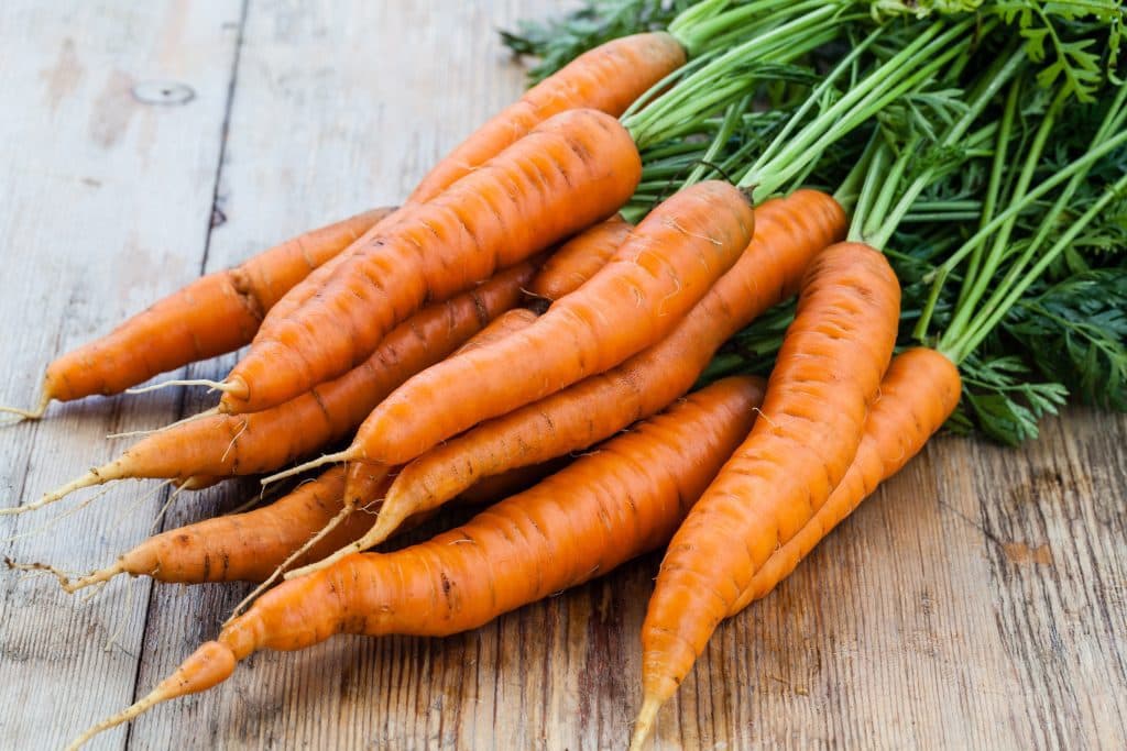 bunch of fresh carrots on wood